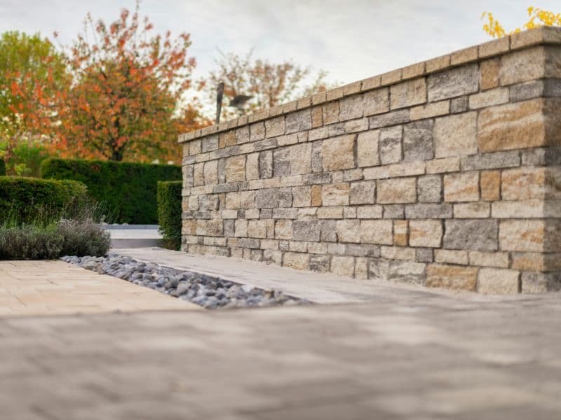 Stone paver patio with retaining wall and outdoor seating
